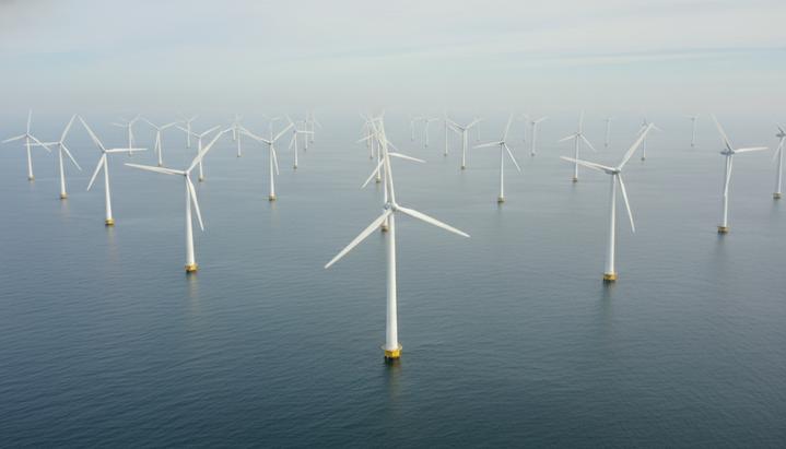 Морская ветряная электростанция с рядами турбин в море, вид с воздуха в пасмурный день.